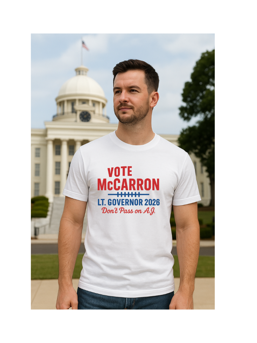Man wearing a white Vote A.J. McCarron t-shirt with political campaign text in front of Alabama Capitol